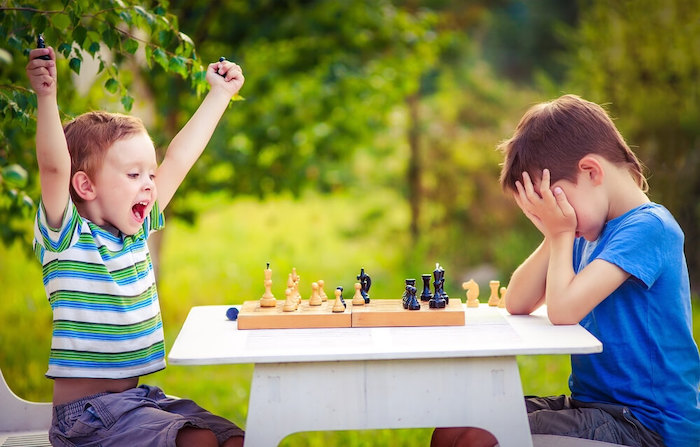 Deux enfants jouent et gagnent une partie d'échecs