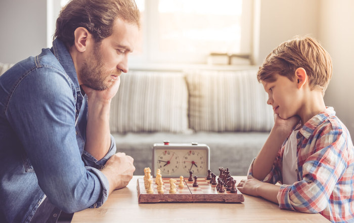 Un papa et son fils font une partie d'échecs chronométré