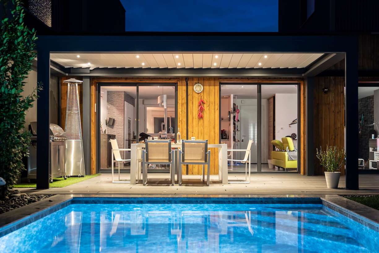 Pergolas autoportante sur terrasse bois avec coin barbecue et devant piscine