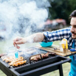 Grilladin cuisinant du poulet sur un barbecue