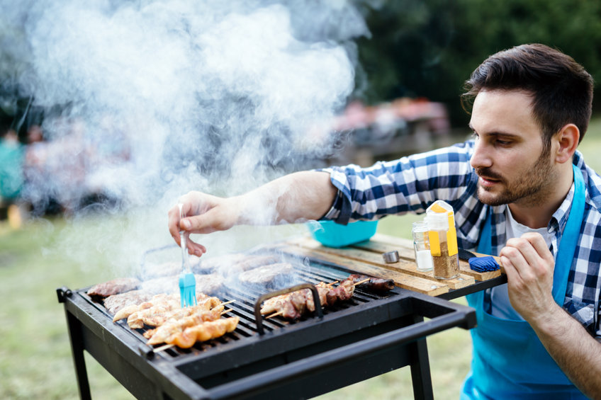 Grilladin cuisinant du poulet sur un barbecue