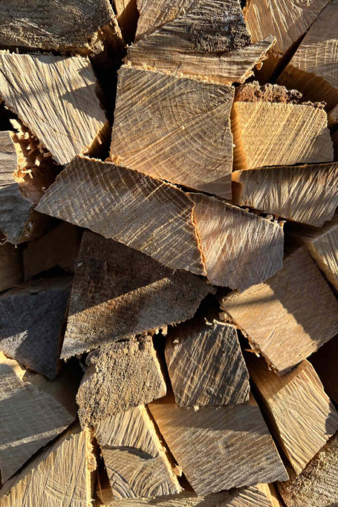 Bûches de chêne et de hêtre fendues, stockées sous abri pour le séchage